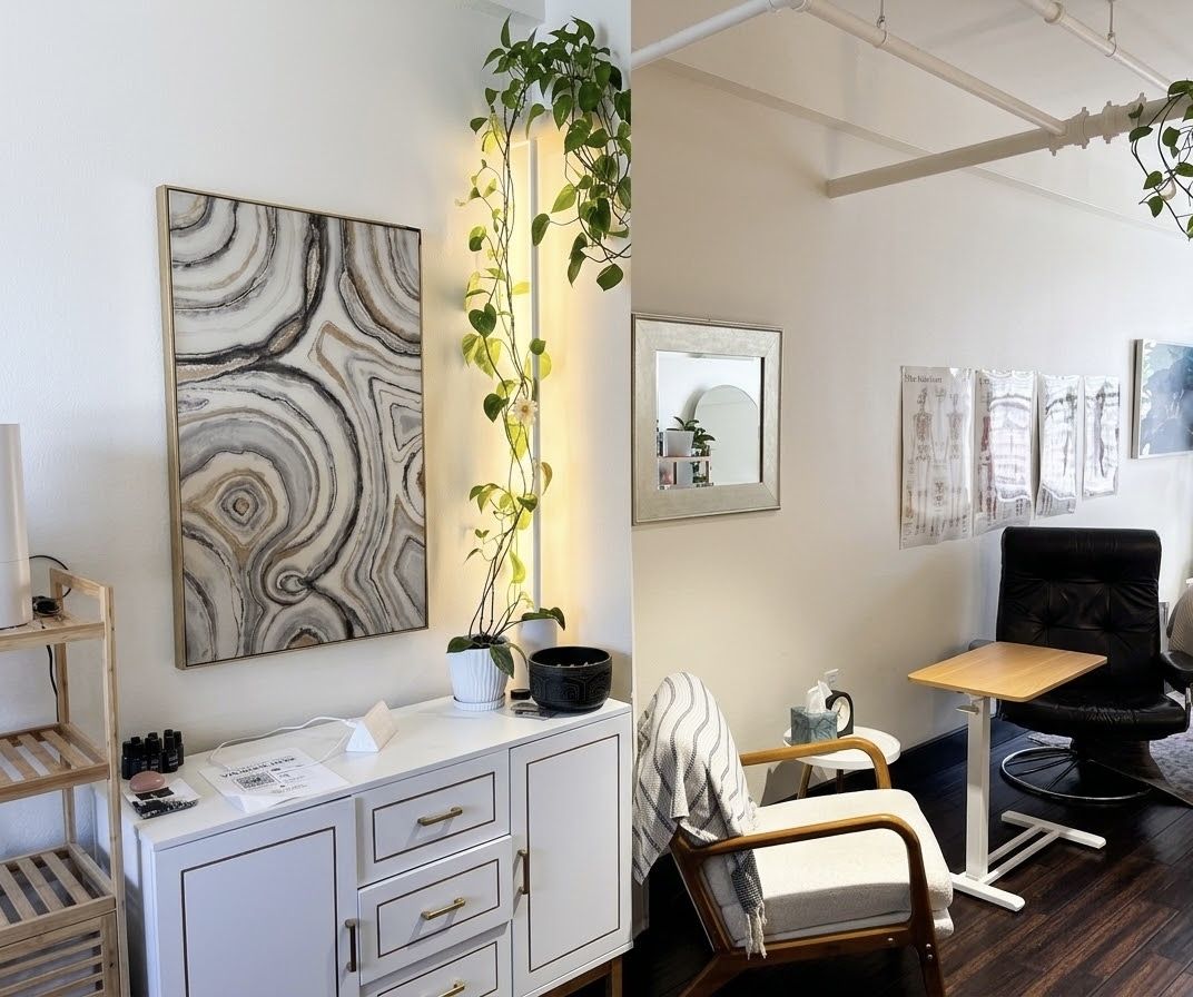 The Kind Hearts Psychiatry office, with a white cabinet, a trailing pothos plant, and a large marbled canvas on the wall